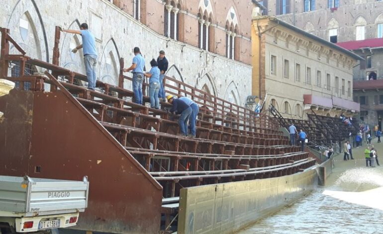 Montaggio del palco delle comparse, operai al lavoro  per recuperare dopo il maltempo