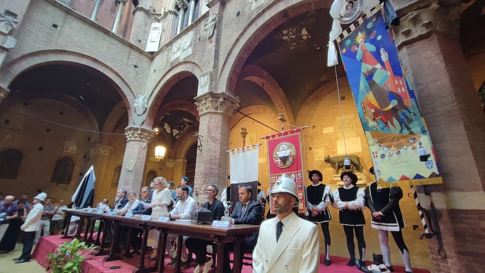 Barberi in corsa tra terreno e celeste nel Palio di Guasco. Svelato il Drappellone dedicato all’Assunta