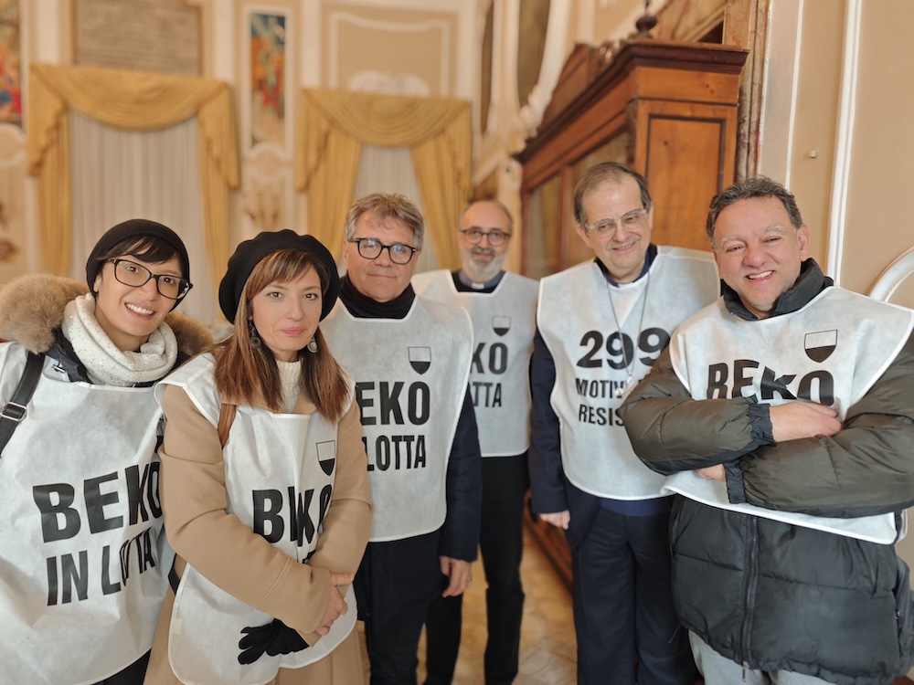 I lavoratori della Beko accolti dal cardinale Lojudice che indossa la pettorina di protesta